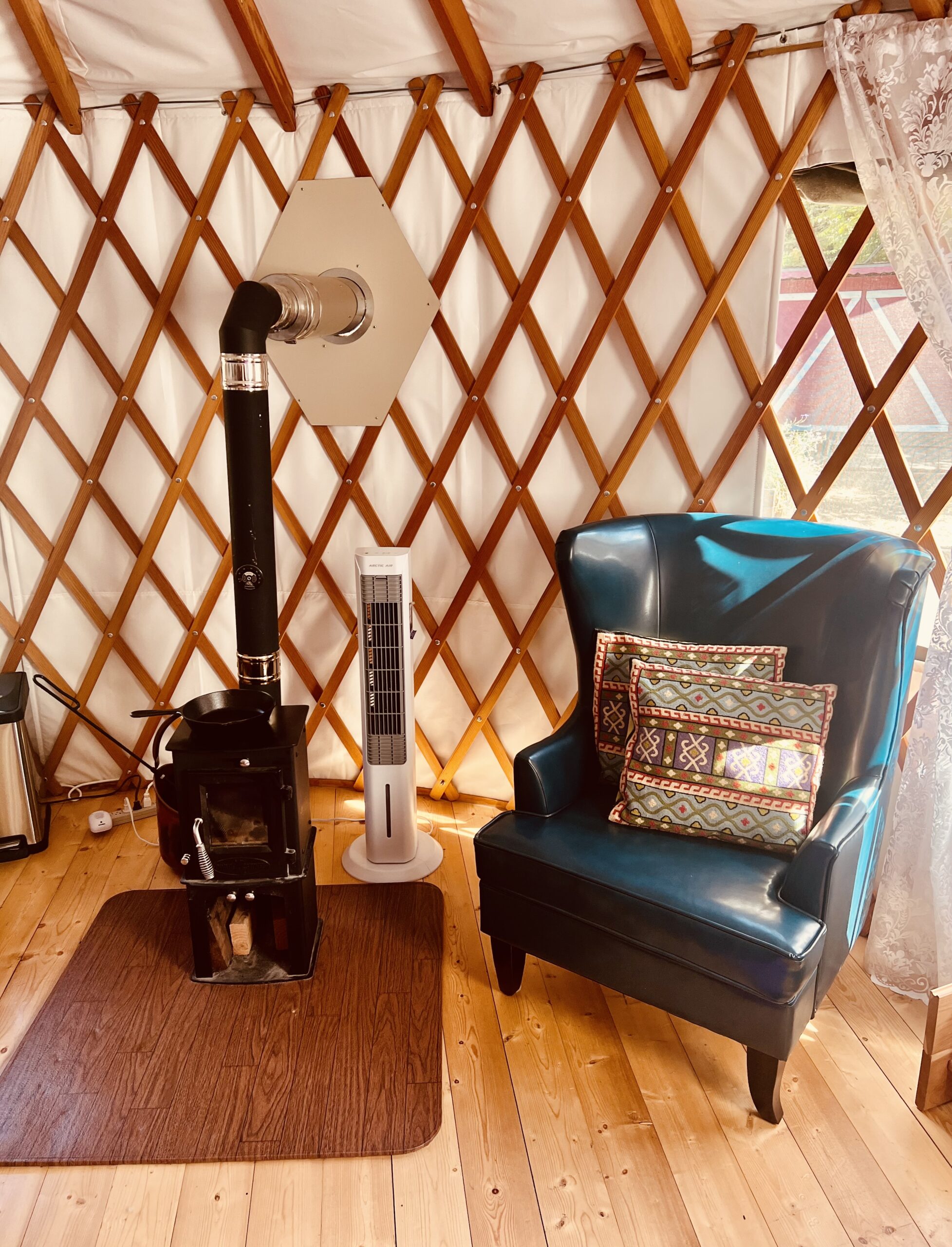 16’ round green Pacific Yurt with tiny fireplace